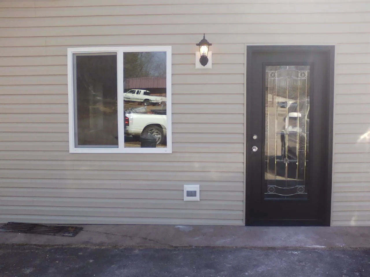 New siding, window and entry door on the side of an addition in Letts