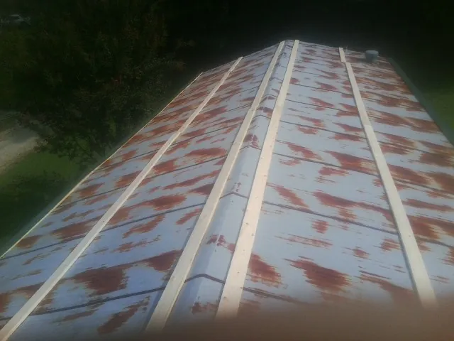 Rusted metal roof panels with new wood purlins before replacement — Storm Damage Roof Repair in Letts by Roofing Brothers